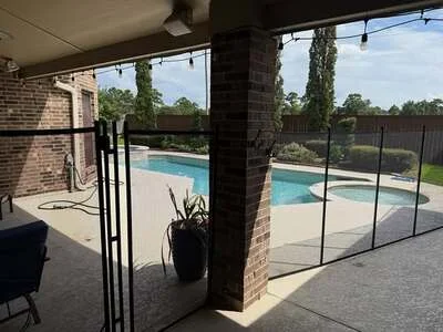 Frameless glass pool fence with black aluminum frame around in-ground pool